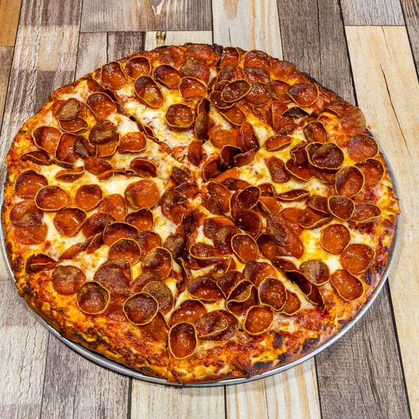 A large, round pepperoni pizza with a crispy crust and melted cheese on a wooden table.