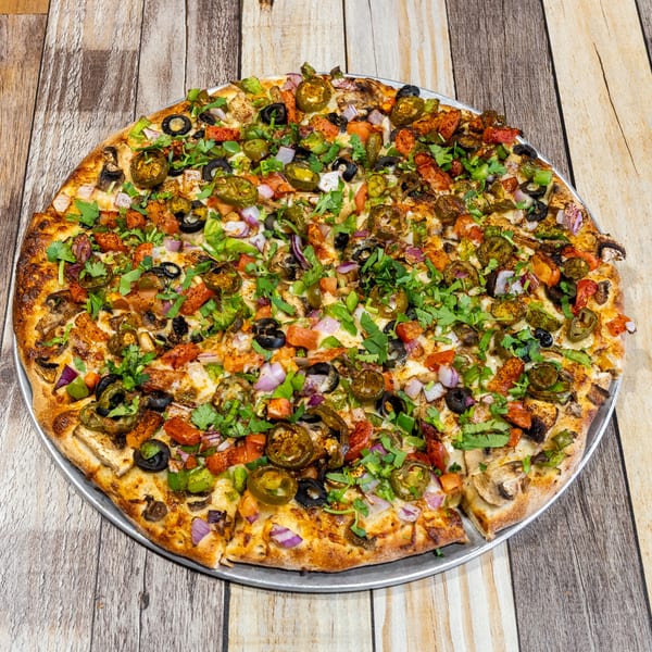 A large, round pizza covered with diverse toppings, including olives, jalapenos, and cilantro.