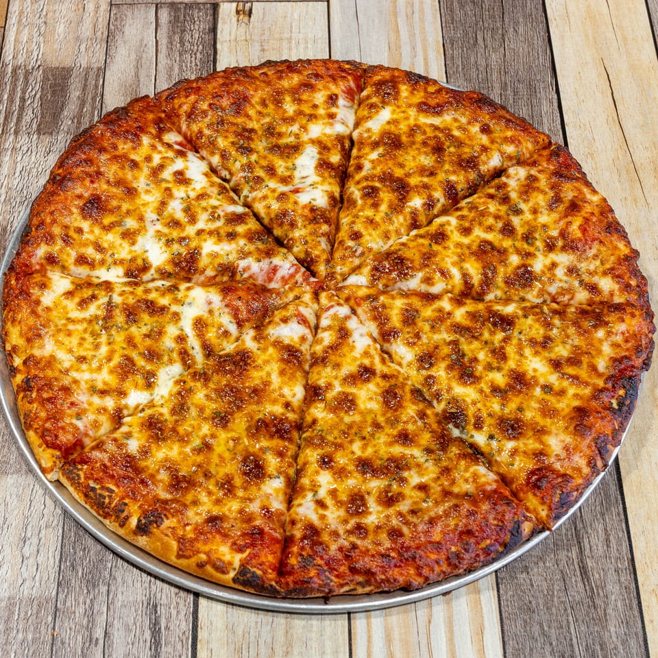 A whole cheese pizza, cut into eight slices, on a metal pan over a wooden table.